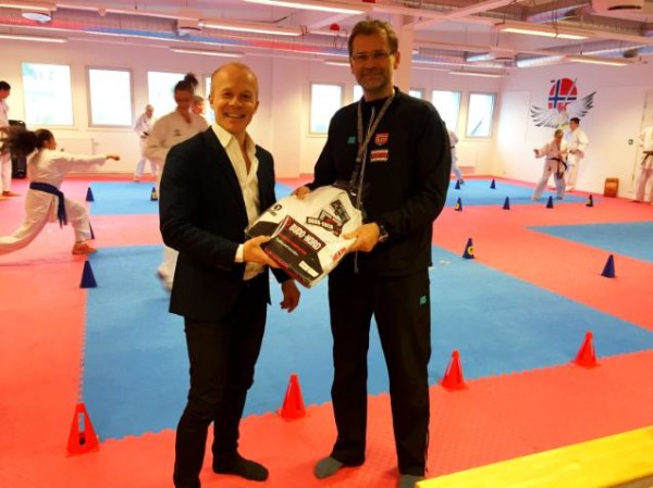 Morten Alstadsæther som er trener i karate mottar utstyr til landslaget fra Fredrik Bjertnæs i Fighter Sport.